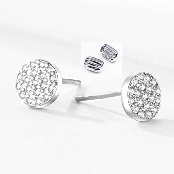 Detail dámských šroubkových stříbrných náušnic kolečka s čirými zirkony