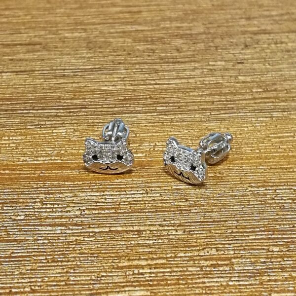 Detailní pohled na dívčí stříbrné náušnice kočičky se zirkonky