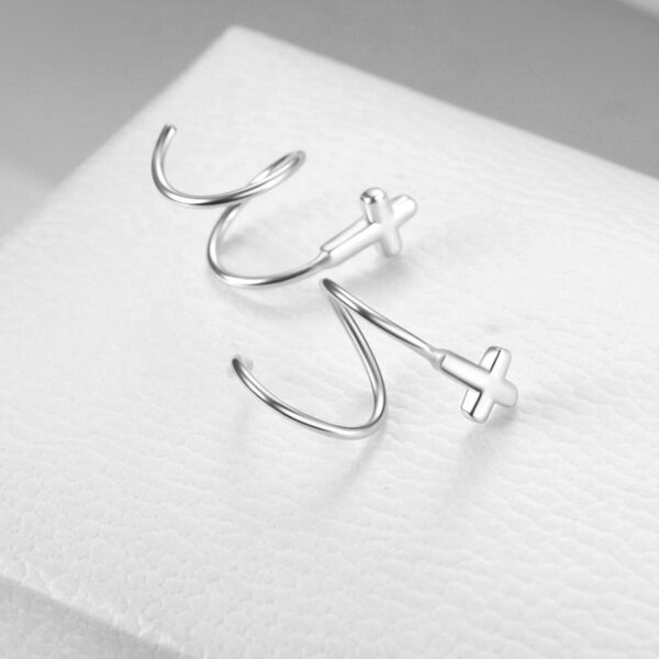 Detailní pohled na dámské stříbrné náušnice spirálky s křížkem