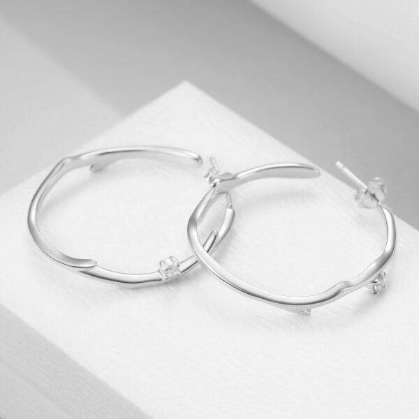 Detailní pohled na dámské stříbrné náušnice kruhy zdobené se zirkony