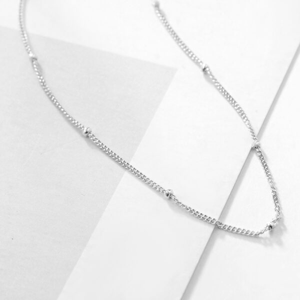 Detail dámského stříbrného řetízku panzer s kuličkami