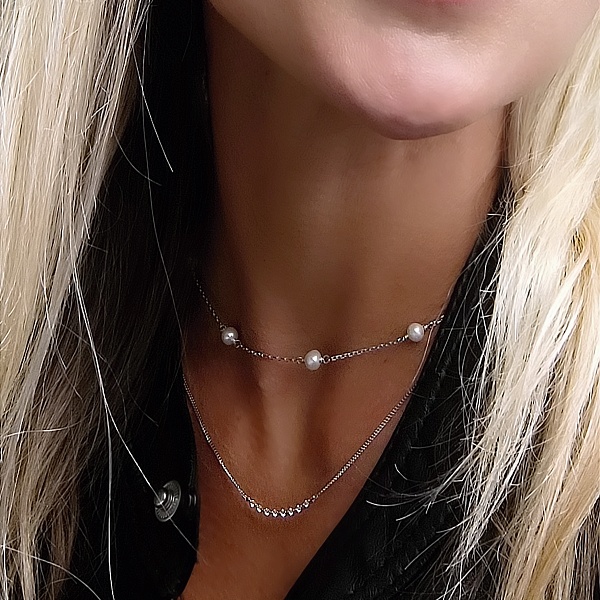 Moderní dámský stříbrný náhrdelník s řadou jemných zirkonů v kombinaci s perličkami