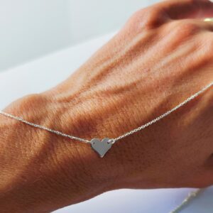 Elegantní stříbrný náhrdelník se zavěšeným přívěskem ve tvaru srdce, minimalistický design.