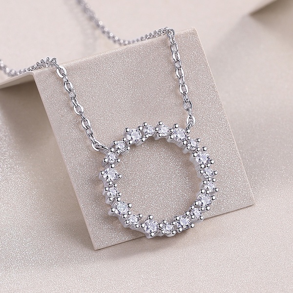 Detailní pohled na stříbrný náhrdelník kolečko dokola osazeným třpytivými zirkony