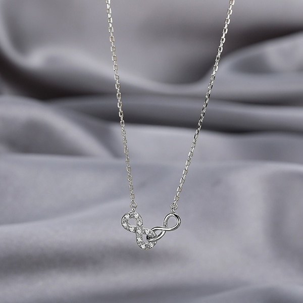 Detailní pohled na dámský stříbrný náhrdelník dva spojené symboly nekonečna se zirkony