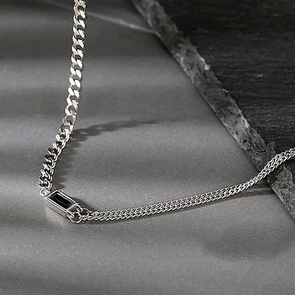 Detailní pohled na dámský stříbrný dvojitý náhrdelník s dominantní ozdobou z černého skla evokující Onyx