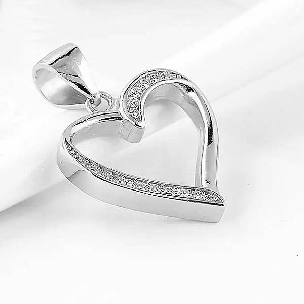 Detailní pohled na stříbrný přívěsek srdce se zářícími zirkony