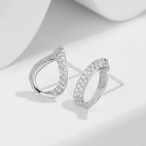 Detail stříbrných náušnic slza osazených zirkony